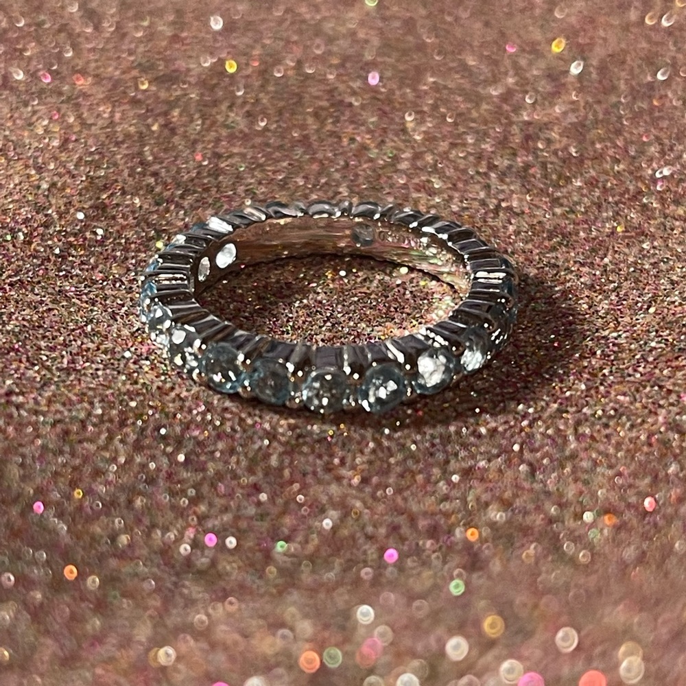Sterling silver ring with blue stones surrounding it.
